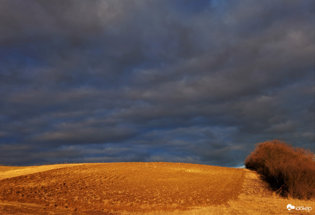 Napsütötte kaszáló és a sötét délutáni felhők