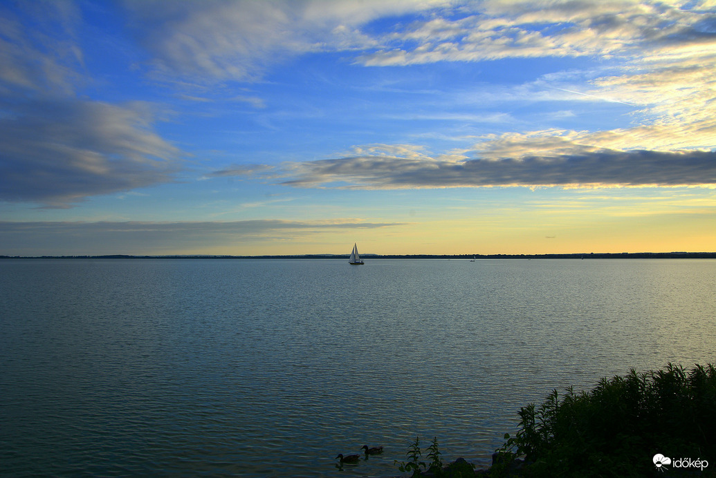 Távolban egy vitorlás naplemente idején 05.30.