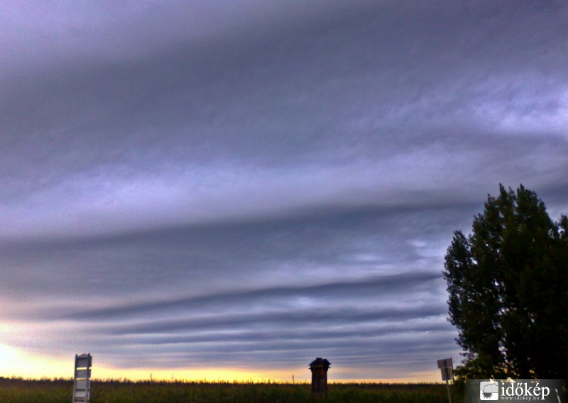 távoli naplemente a csíkok takarásában