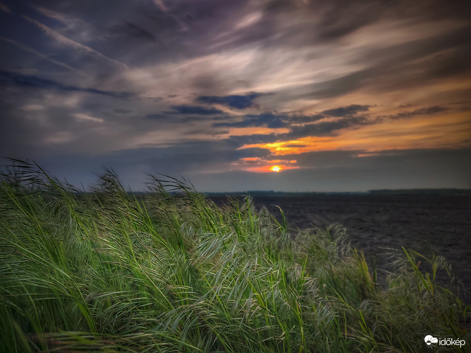Erősen felhős, távoli zivatartól morajlós naplemente