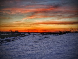 Hideg, havas táj és a forrósodó alkonyati égbolt